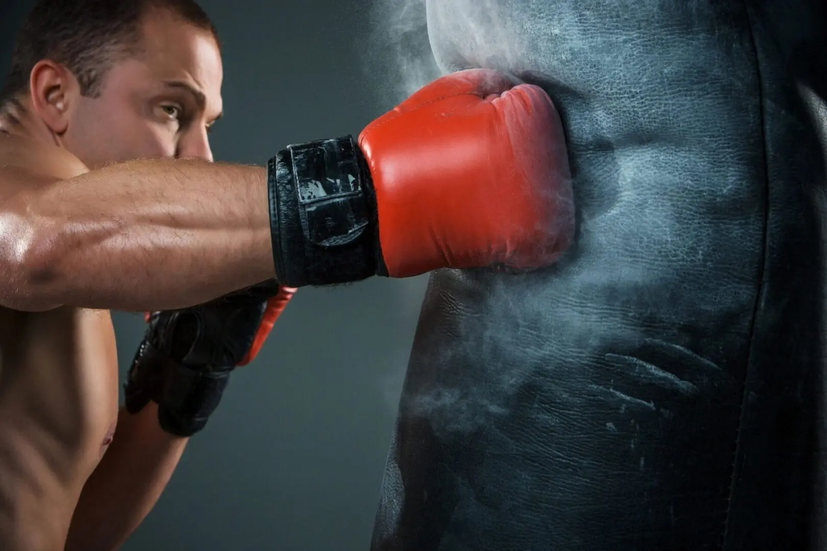 A man wearing red boxing gloves is hitting the wall.